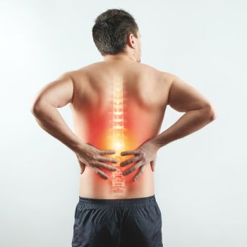 A man holds his lower back in pain, with a highlighted spine and glowing area indicating discomfort—perfect for a Sciatica Specialist NYC seeking to illustrate nerve related injury or back issues